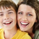 A child and a mature woman smiling together