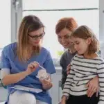 What Does Family Dentistry Include? Care for Every Age in Arlington, VA 6 Girl showing her lost tooth to the dentist